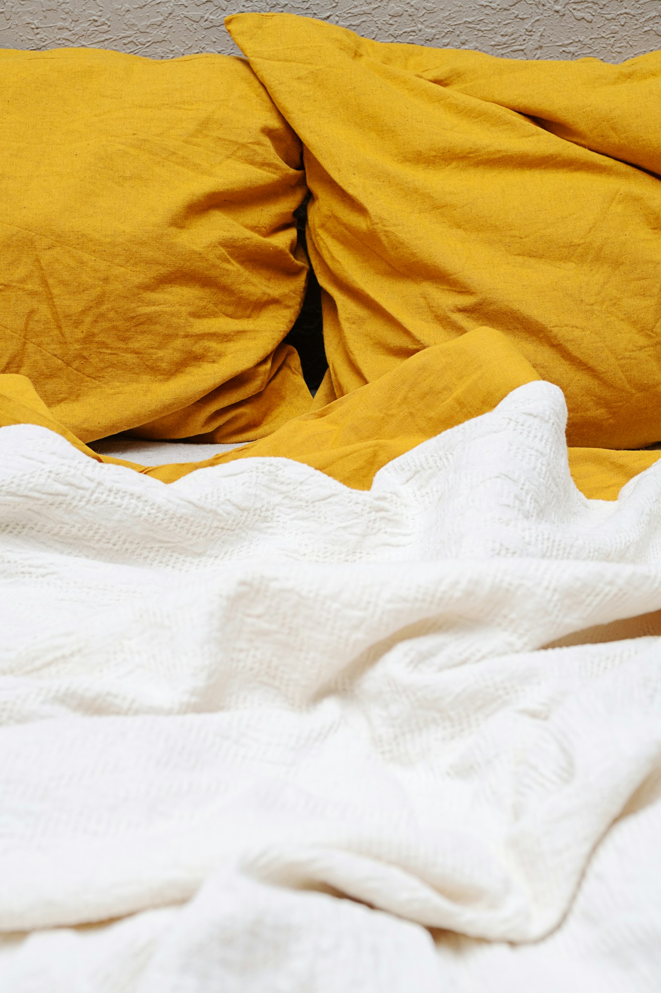 Crumpled linen bed sheets and pillows in the morning.